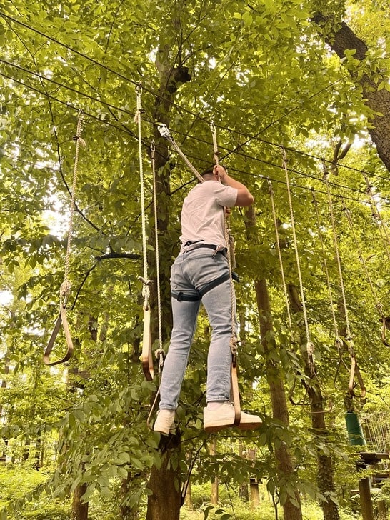 Person beim Seilklettern von hinten